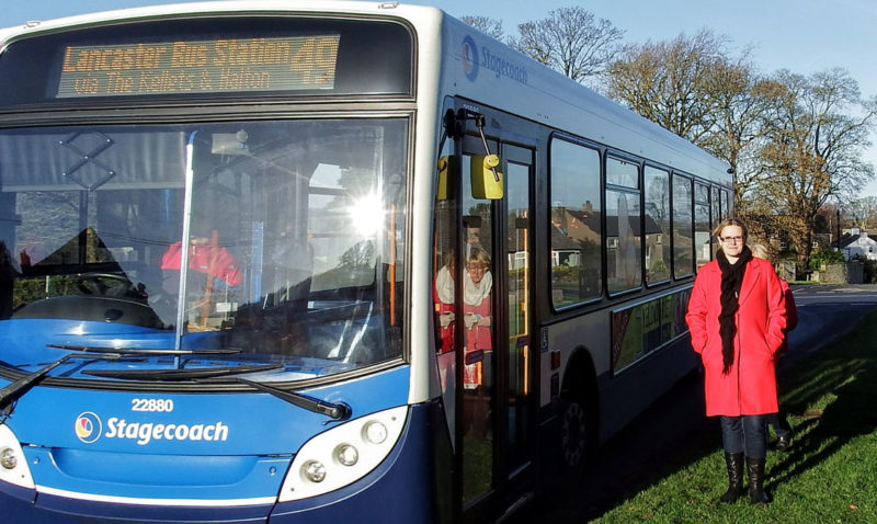 Lizzi Collinge stands next to a bus 