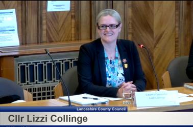 Lizzi Collinge chairs a committee meeting in a wood panelled room